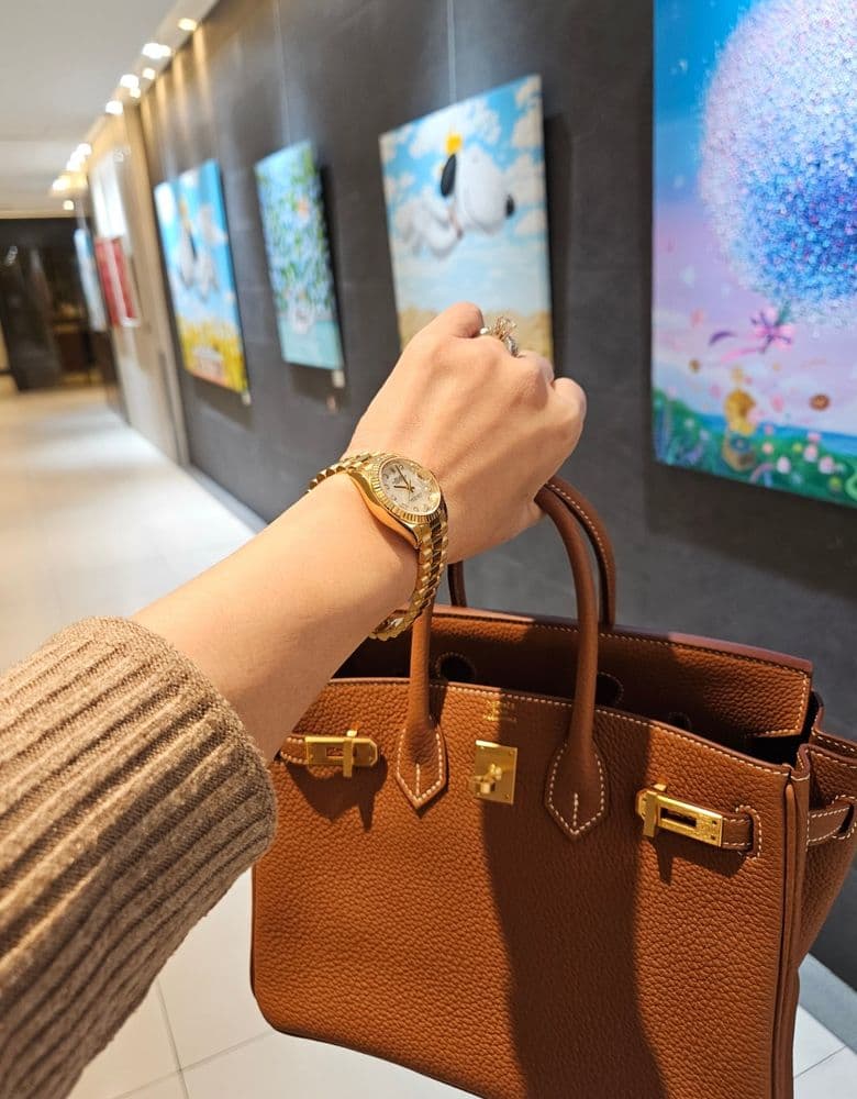 Layering jewelry with a Rolex gold Datejust with ten diamond markers.