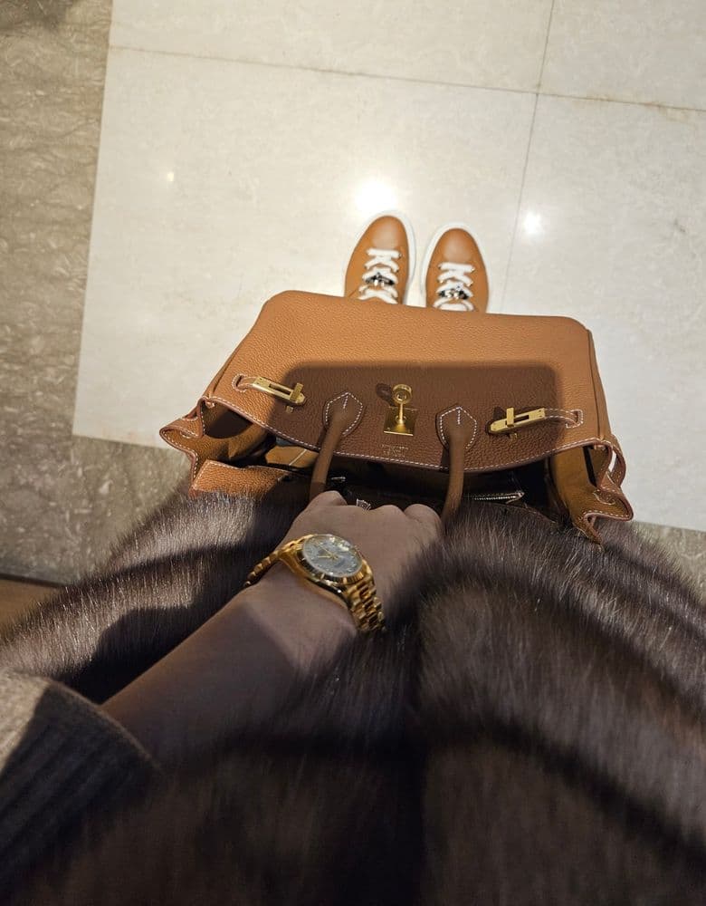 Layering jewelry with a Rolex gold Datejust with ten diamond markers.